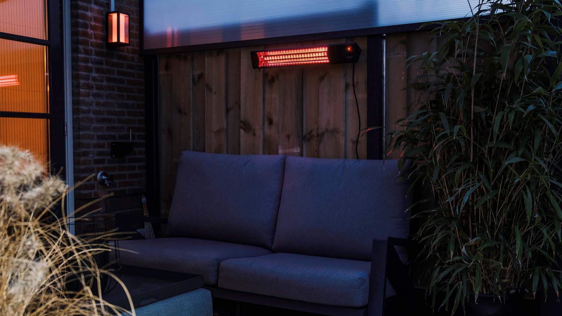 Zwarte Sunred Triangle Dark SMART wandmodel heater in de gezellige sfeervolle tuin