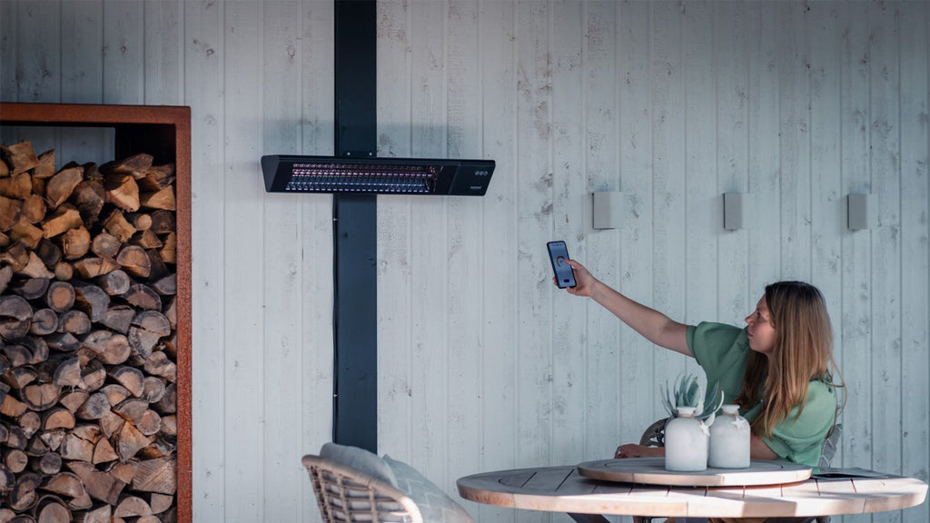 Zwarte Sunred Triangle Dark SMART wandmodel heater op afstand bestuurbaar in gezellige tuin

