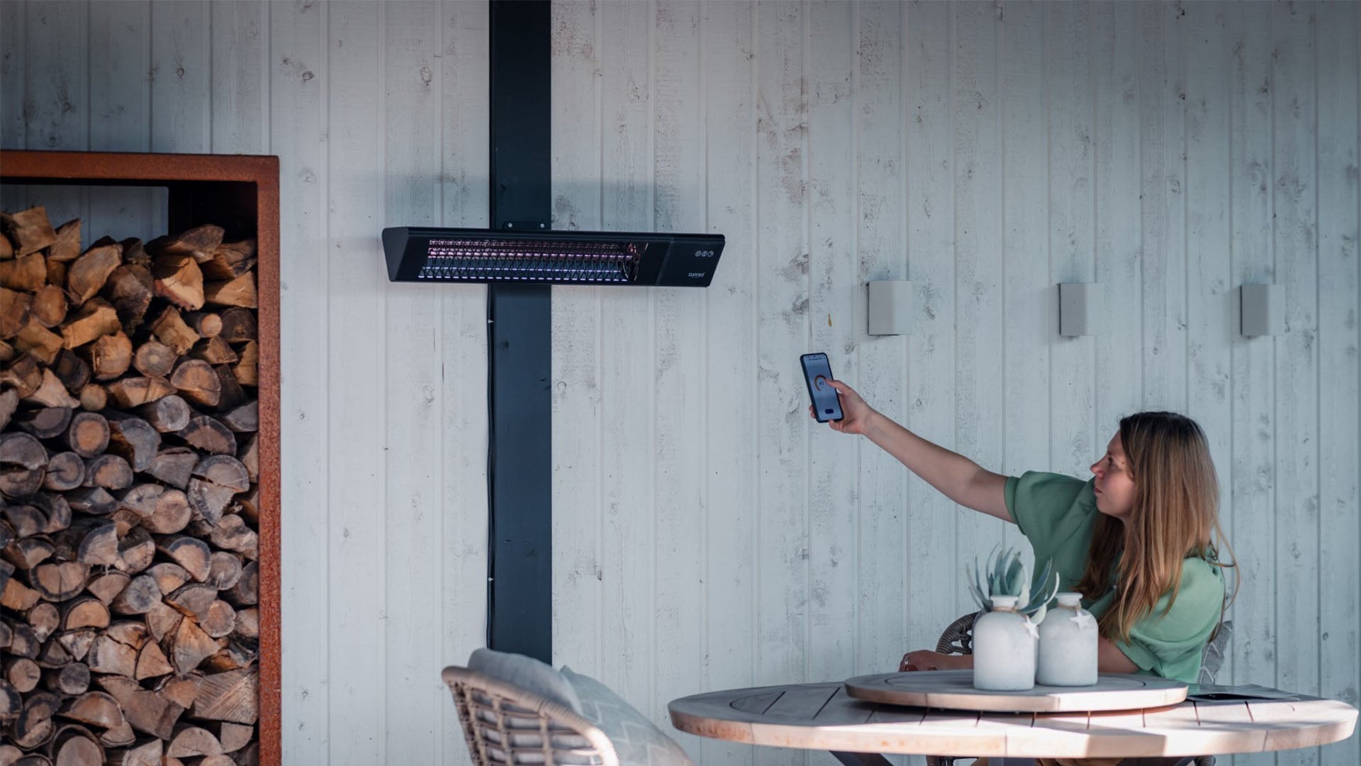 Zwarte Sunred Triangle Dark SMART wandmodel heater op afstand bestuurbaar in gezellige tuin

